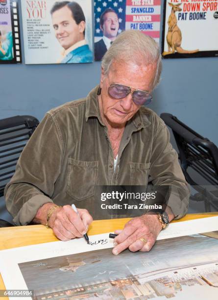 Singer Pat Boone signs a 70th Anniversary Commemorative print honoring the Exodus ship's contribution to Jewish and world history at Pat Boone...