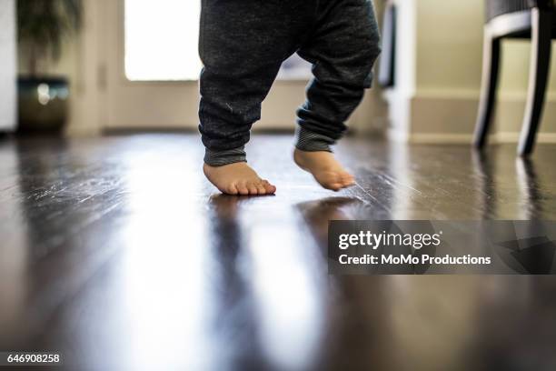 closeup of toddler taking first steps - barefoot child stock pictures, royalty-free photos & images