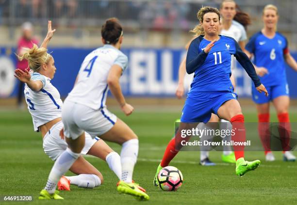 Claire Lavogez of France tries to play the ball past Steph Houghton and Lucy Bronze of England during the SheBelieves Cup at Talen Energy Stadium on...