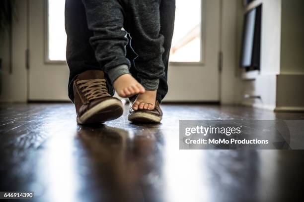 toddler boy (2 yrs) walking on father's feet, closeup - part of the day stock pictures, royalty-free photos & images