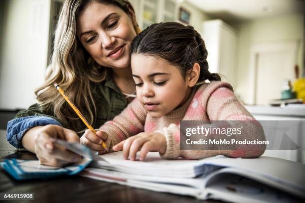 mother and daughter (7 yrs) doing homework - mother and child imagens e fotografias de stock