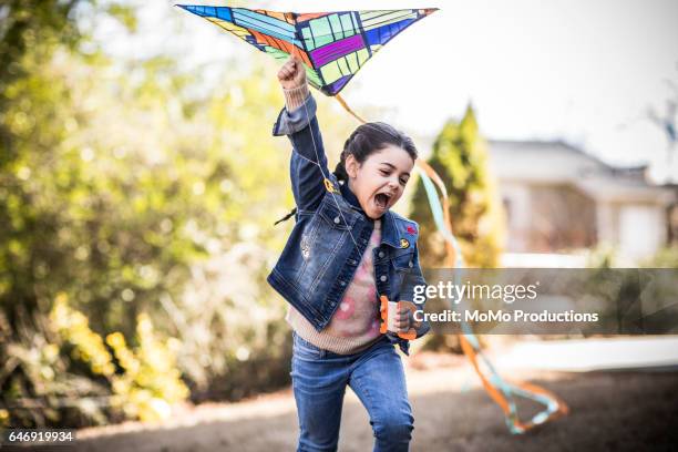 girl (7yrs) flying kite in backyard - kite toy stock pictures, royalty-free photos & images