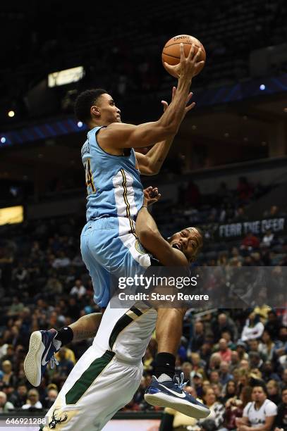 Greg Monroe of the Milwaukee Bucks is fouled by Gary Harris of the Denver Nuggets during the second half of a game at the BMO Harris Bradley Center...