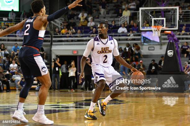 East Carolina Pirates guard Caleb White brings the ball up court against Connecticut Huskies guard Jalen Adams in a game between the Connecticut...