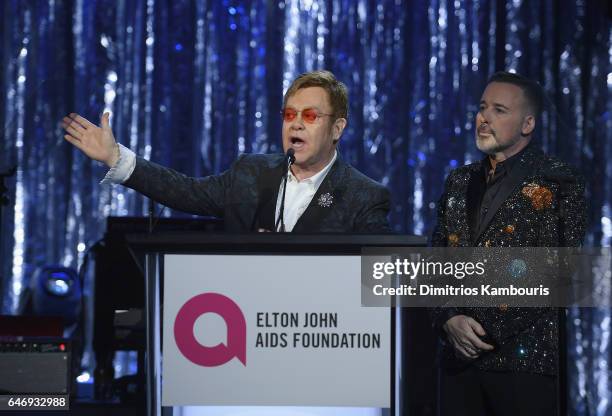 Hosts Elton John and David Furnish speak onstage at the 25th Annual Elton John AIDS Foundation's Academy Awards Viewing Party at The City of West...