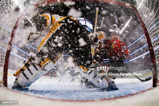 The ice sprays as Jonathan Toews of the Chicago Blackhawks approaches goalie Marc-Andre Fleury of the Pittsburgh Penguins in the first period at the...