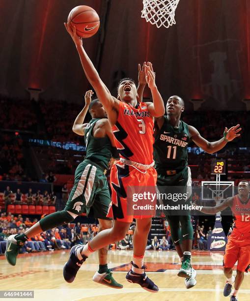 Te'Jon Lucas of the Illinois Fighting Illini shoots the ball between Alvin Ellis III and Lourawls Nairn Jr. #11 of the Michigan State Spartans at...