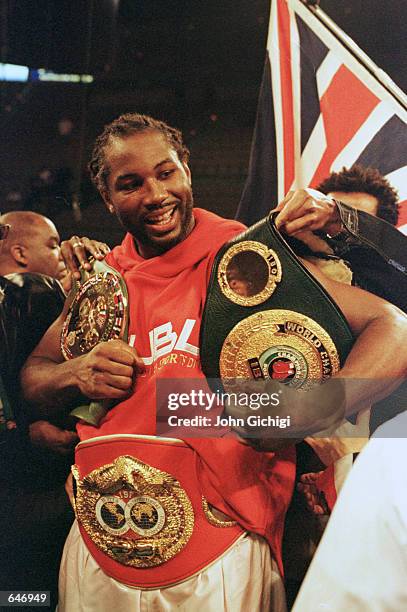 Lennox Lewis celebrates with his WBC/IBC Heavyweight Championship belts after defeating David Tua at the Mandalay Bay Resort & Casino in Las Vegas,...