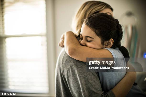 Mother and daughter (7yrs) hugging, closeup