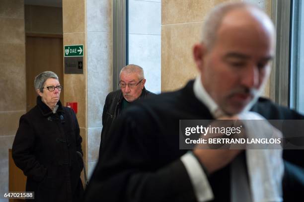 Plaintiffs Alain and Suzanne Lales, walk behind their lawyer Emmanuel Molina ahead of a hearing of the trial of five men charged for their alleged...