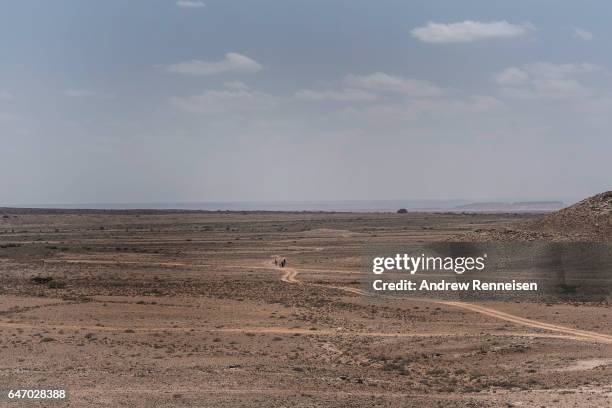 Group of people walk outside of an IDP camp on February 24, 2017 in Karin Sarmayo, Somalia. Brief rains brought an estimated 100,000 people to the...