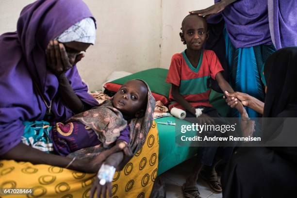 Abdullahi Mohamud cries next to his mother Sahro Mohamed Mumin and brother, Abdulrahman Mahamud as a nurse struggles to find a vein for an injection...