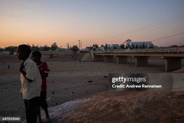 Boys look out over a dried riverbed on February 27, 2017 in Garowe, Somalia. Somalia is currently on the brink of famine with over half of the...