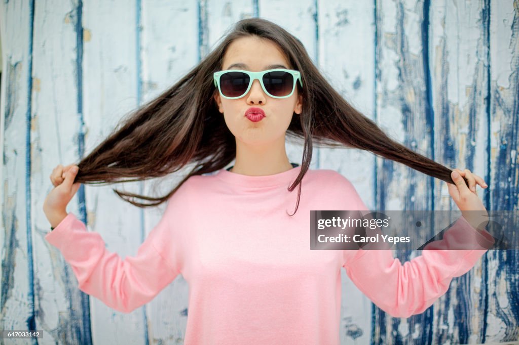 Teenager girl playing with hair with fun expression