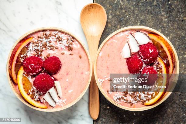 raspberry smoothie bowls on black and white marble - nagerecht-garnering stockfoto's en -beelden