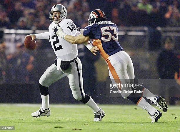 Quarterback Rich Gannon of the Oakland Raiders is under pressure from Bill Romanowski of the Denver Broncos and throws an interception early in the...