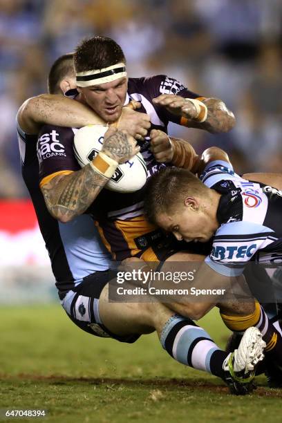 Josh McGuire of the Broncos is tackled during the round one NRL match between the Cronulla Sharks and the Brisbane Broncos at Southern Cross Group...