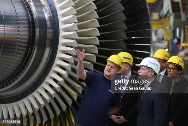 German President Joachim Gauck listens to a worker during a visit by Gauck to the Siemens gas turbine factory on March 2, 2017 in Berlin, Germany....