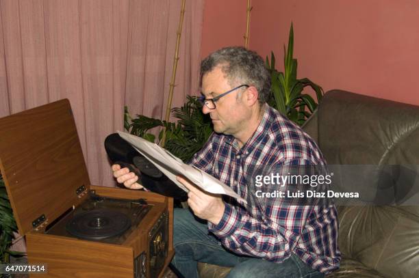man reading vinyl record cover - hombres de mediana edad stock-fotos und bilder