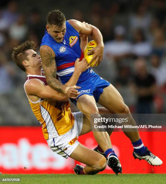 Clay Smith of the Bulldogs is tackled by Ben Keays of the Lions during the AFL 2017 JLT Community Series match between the Western Bulldogs and the...