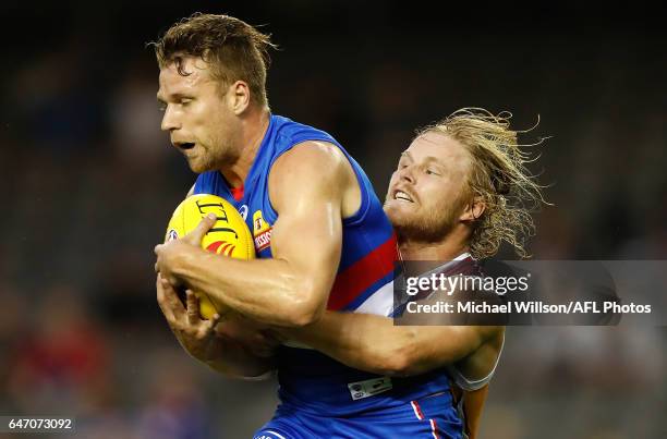 Jake Stringer of the Bulldogs is tackled by Daniel Rich of the Lions during the AFL 2017 JLT Community Series match between the Western Bulldogs and...