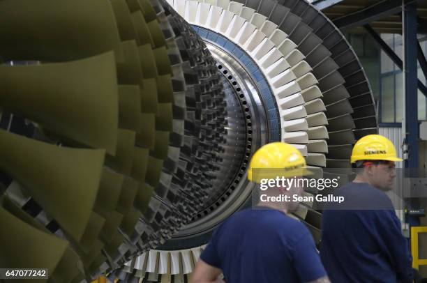 Workers walk past a turbine at the Siemens gas turbine factory on March 2, 2017 in Berlin, Germany. Germany's number of unemployed fell by 15,000 in...