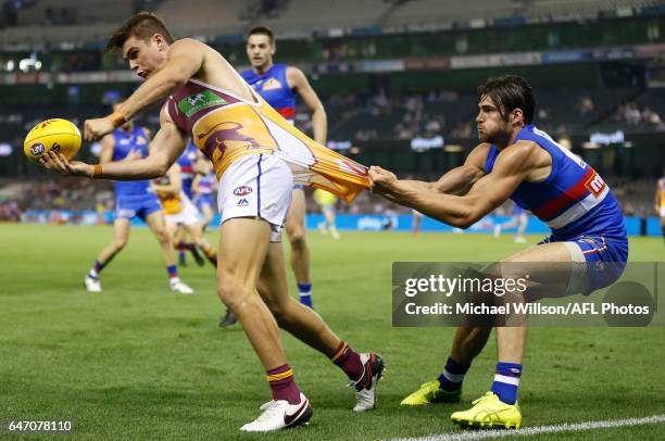 Ben Keays of the Lions is tackled by Easton Wood of the Bulldogs during the AFL 2017 JLT Community Series match between the Western Bulldogs and the...