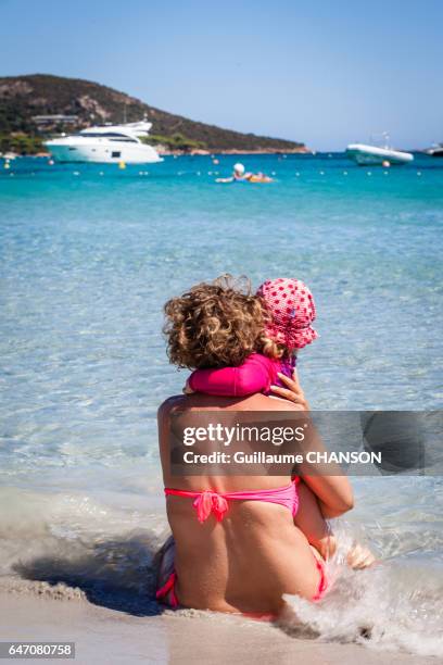 woman and his daughter making a cuddle on a beach at palombaggia, porto-vecchio, corsica, france - affectueux stock pictures, royalty-free photos & images