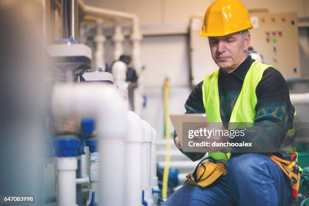 technicus in ketelruim met behulp van tablet pc - water heater stockfoto's en -beelden