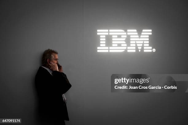 Congress attendee speaks on his mobile phone in front of IBM logo, during the Mobile World Congress on March 1, 2017 in Barcelona, Spain.