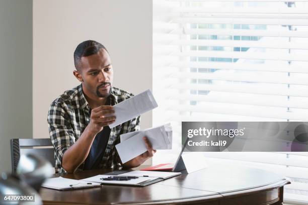 young black man paying bills at home - 20 24 adult male laptop stock pictures, royalty-free photos & images