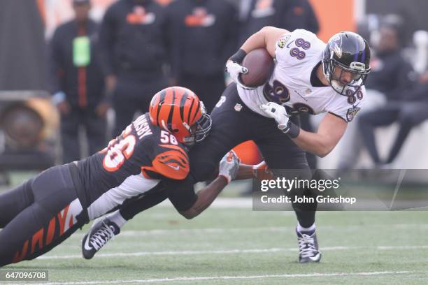 Dennis Pitta of the Baltimore Ravens runs the football upfield against Karlos Dansby of the Cincinnati Bengals during their game at Paul Brown...