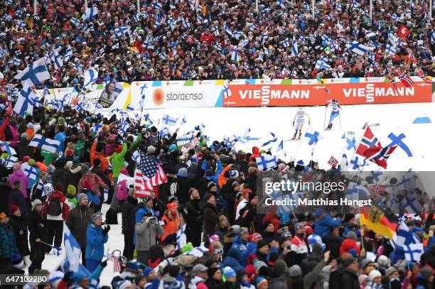 Spectators show their support as Stina Nilsson of Sweden and Krista Parmakoski of Finland race to the finish line during the Women's Cross Country...