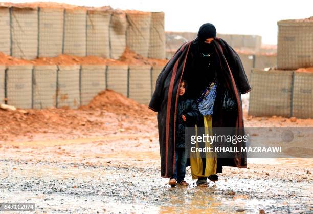Syrian refugee from the informal Rukban camp, which lies in no-man's-land off the border between Syria and Jordan in the remote northeast, walks in...