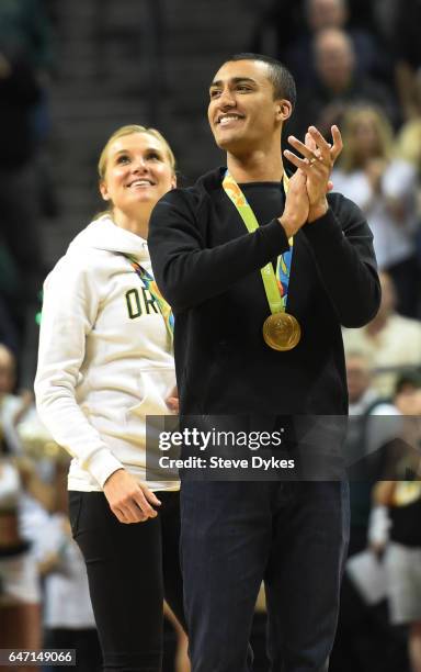 Two time Olympic decathlon champion and former Oregon Duck Ashton Eaton are greeted with applause as they are introduced to the crowd during a time...