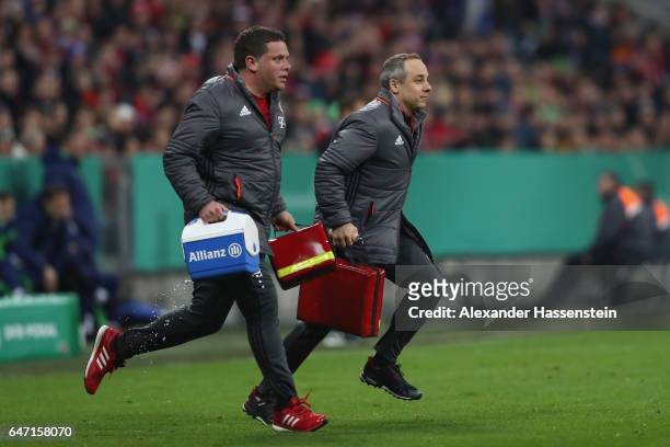 Volker Braun , team Doctor of Bayern Muenchen runs with Christian Huhn, Physiotherapist of Bayern Muenchen during the DFB Cup quarter final between...