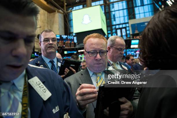 Traders work as they wait for shares of Snap Inc. To open for trading on the floor of the New York Stock Exchange , March 2, 2017 in New York City....