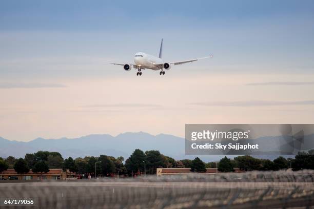 airplane landing on runway with blue sky sunset - live launch arrivals stockfoto's en -beelden