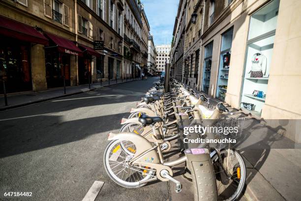 bicicleta compartiendo el sistema de bicicletas aparcadas cerca de rue de rivoli en parís - rue de rivoli fotografías e imágenes de stock