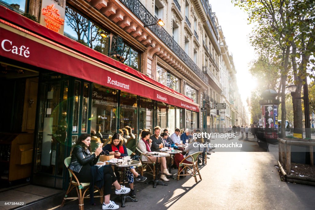People relaxing, eating and drinking in restaurant in Paris, France