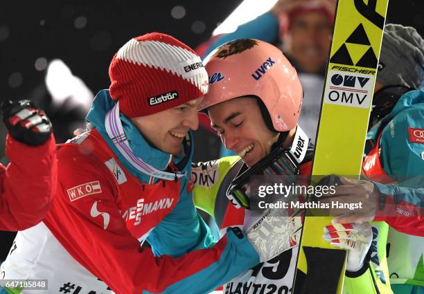 Stefan Kraft of Austria is congratulated by Michael Hayboeck of Austria as he wins gold during the Men's Ski Jumping HS130 at the FIS Nordic World...