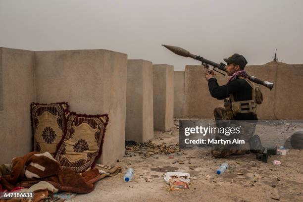 An Iraqi Counter Terrorism Service officer of the Golden Division aims an RPG at an Islamic State sniper position in the west Mosul district of...