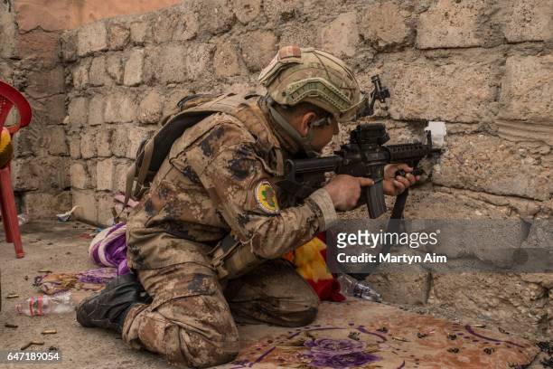 An Iraqi Counter Terrorism Service officer of the Golden Division aims at an Islamic State sniper position in the west Mosul district of al-Mamoun,...