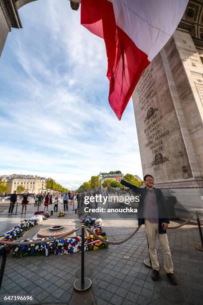 turisti in visita al famoso arco di trionfo, parigi, francia - eternal flame paris foto e immagini stock