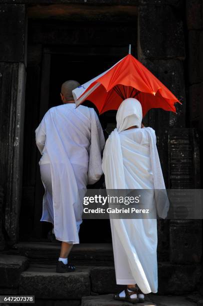 thai buddhists entering an ancient khmer temple - phimai stock pictures, royalty-free photos & images