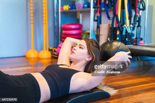 femme, renforcer ses muscles abdominaux avec un médecine-ball - asian six pack photos et images de collection