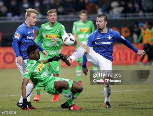 Fabian Holland of Darmstadt and Ba-Muaka Simakala of Gladbach and Jerome Gondorf of Darmstadt battle for the ball during the Bundesliga match between...