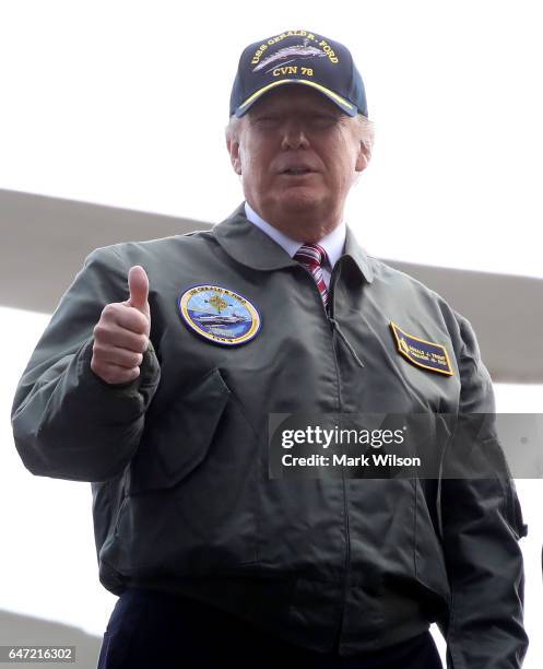 President Donald Trump gives a thumbs up while going up on a aircraft elevator after speaking to members of the U.S. Navy and shipyard workers on...