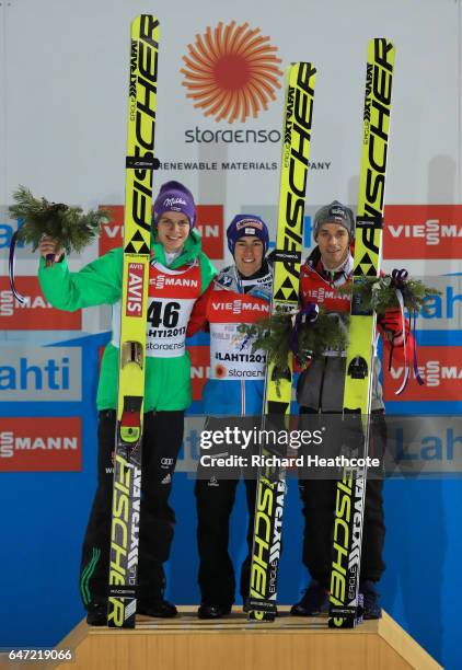 Silver medalist Andreas Wellinger of Germany, gold medalist Stefan Kraft of Austria and bronze medalist Piotr Zyla of Poland pose during the flower...