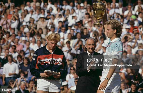 Swedish tennis player Stefan Edberg holds up the Gentlemen's Singles Trophy after defeating Boris Becker in the final of the Men's Singles tournament...